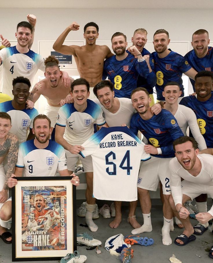 a group of men posing for a photo with a soccer jersey and an award plaque