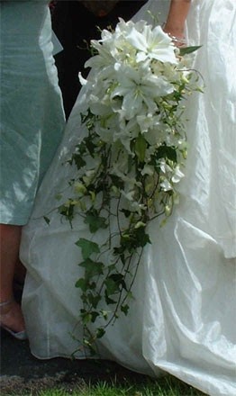 the bride and groom are walking down the street with their bouquets in hand,