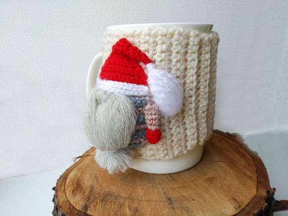 a knitted santa hat on top of a coffee cup