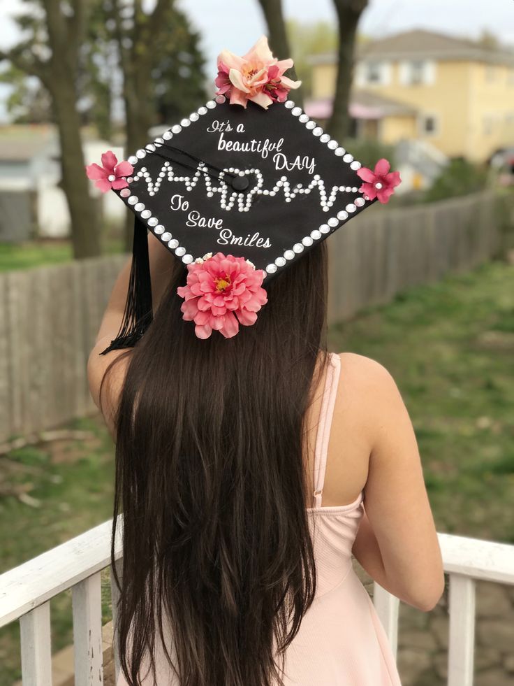 a woman wearing a graduation cap with flowers on it