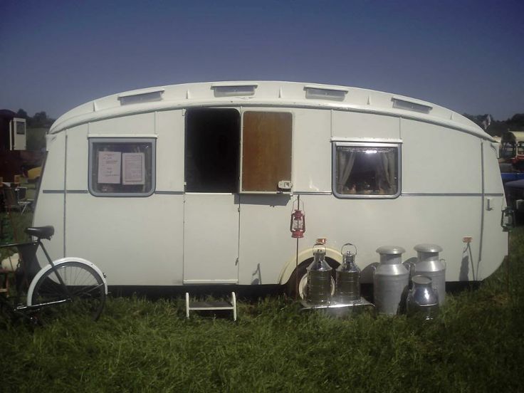 an old trailer is parked in the grass