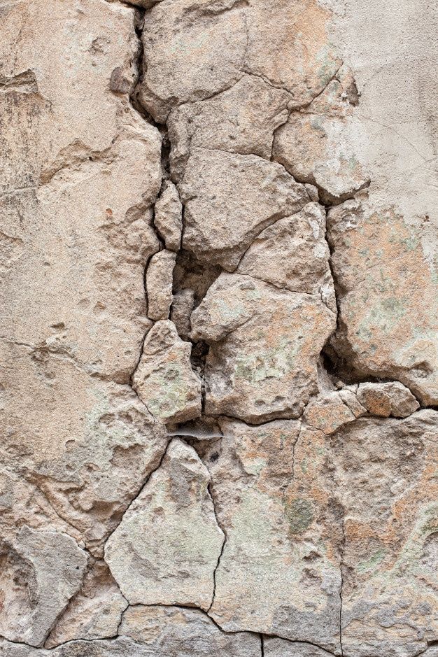 an old rock wall with cracks in it