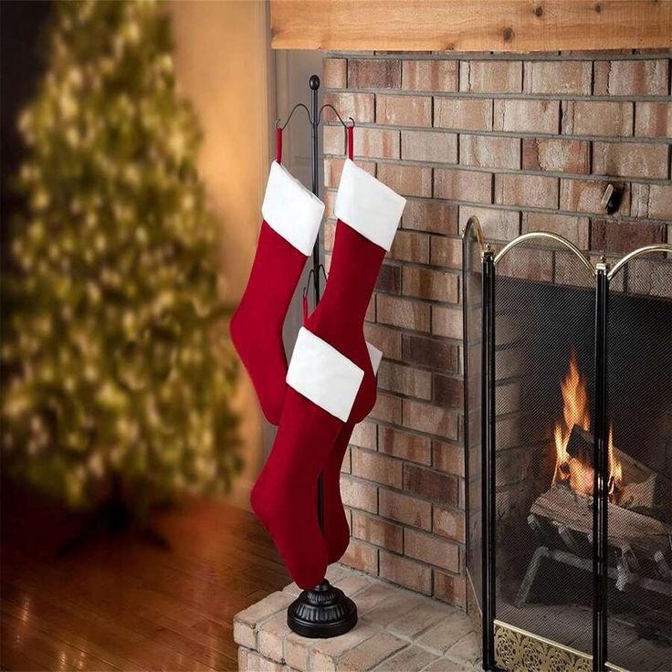 a fireplace with stockings hanging from it's sides next to a christmas tree and fire place