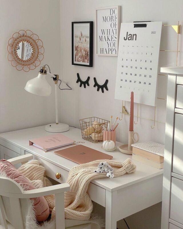 a white desk with two chairs and a calendar on the wall next to it,