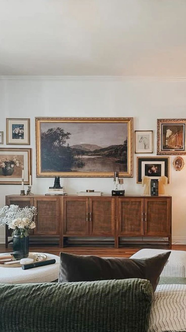 a living room filled with furniture and pictures on the wall