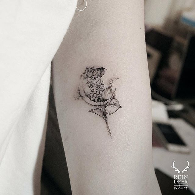 a woman's arm with a tattoo on it that has a flower in the middle