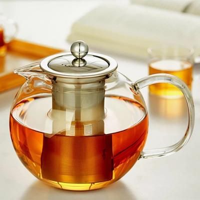 a glass tea pot filled with liquid on top of a table