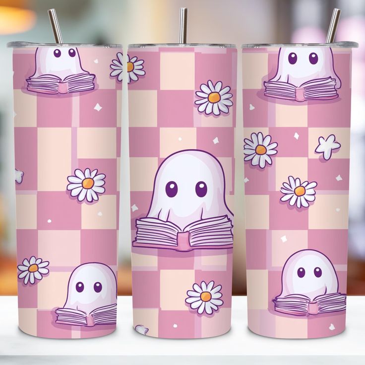 three pink tumblers with cartoon characters and flowers on them, one is reading a book