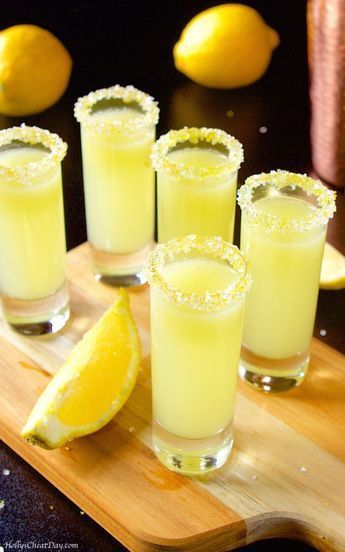 several glasses filled with lemonade sit on a cutting board