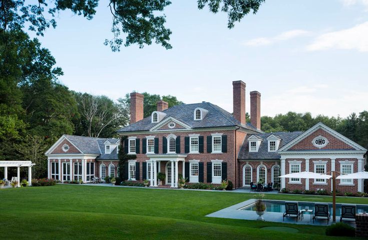 a large brick house with white trim and black shutters