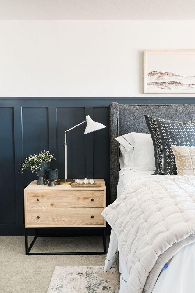 a bed room with a neatly made bed and a night stand next to the bed