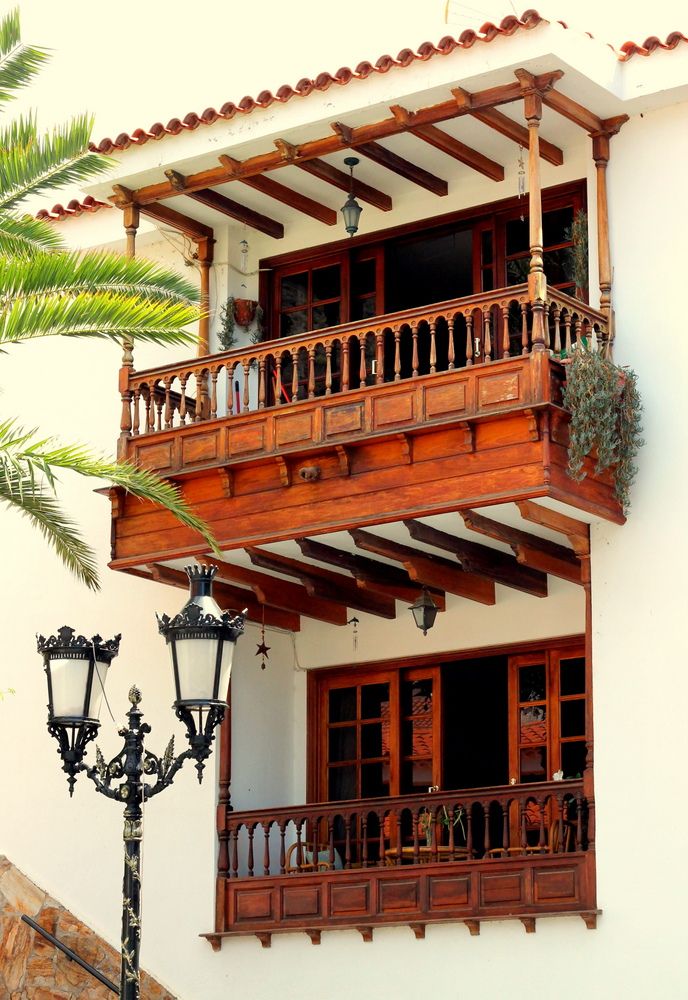 a building with wooden balconies and balconys next to a street light in front of it