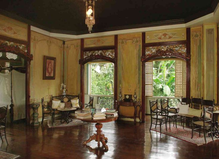 an ornately decorated living room with wooden floors and walls, along with large windows