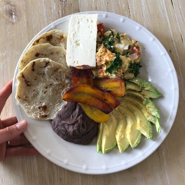 a white plate topped with lots of different types of food on top of a wooden table