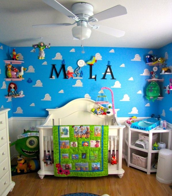 a child's room with blue walls and white furniture, including a crib