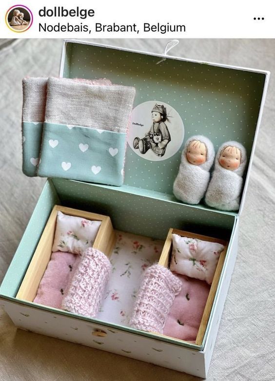 an open box with two baby dolls in it