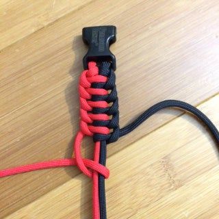 a black and red leash on top of a wooden floor