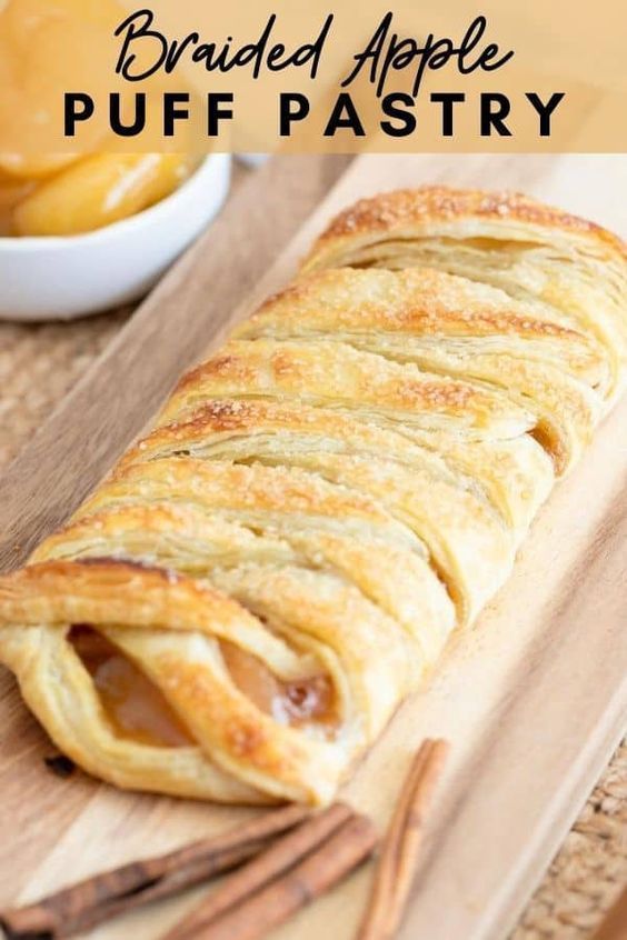 baked apple puff pastry on a cutting board with cinnamon sticks