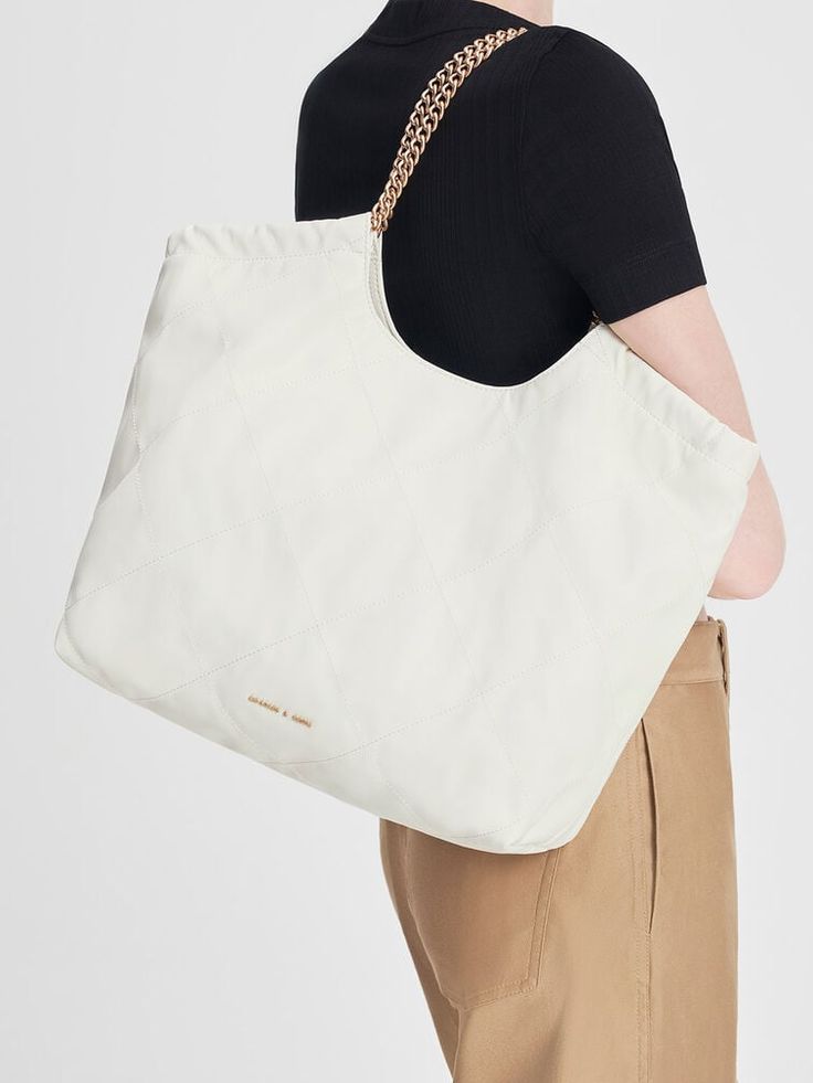 This product is made with at least 20% sustainable materials by weight. CHARLES & KEITH uses recycled, degradable, organic, and water-based materials in our eco-conscious collection. In match-all white, this neutral-toned iteration of our braided handle tote bag will slot seamlessly into your wardrobe rotation. With a magnetic closure that opens to reveal a extra large and capacious interior and gold-toned braided chain double handles that are edgy and chic at once, this bag has all the makings of a style staple that you will want to use on repeat. Charles And Keith Bags, Charles Keith, On Repeat, White Bag, Large Bags, Extra Large, Product Launch, Faux Leather, Tote Bag