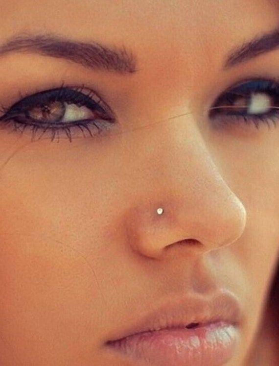 a woman with piercings on her nose looking at the camera