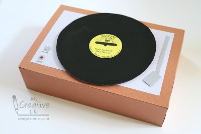 a record player in a cardboard box with a knife and fork