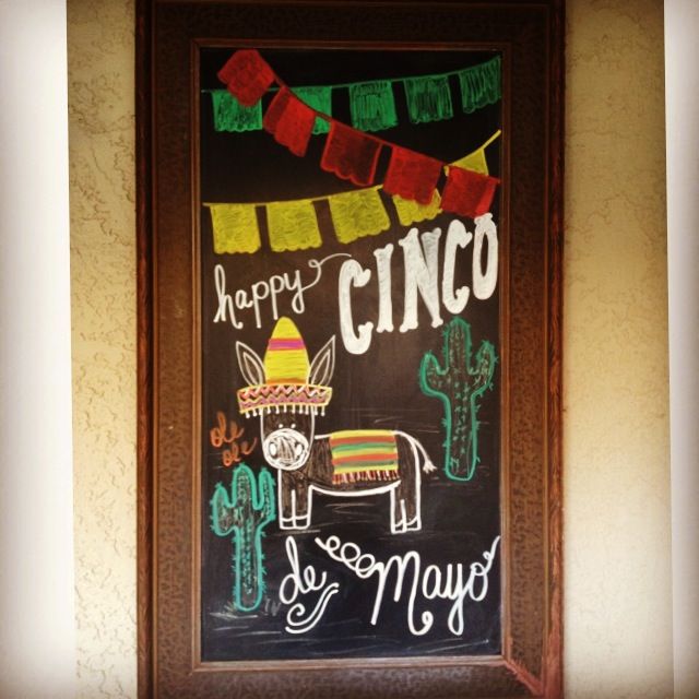 a chalkboard with mexican food on it in front of a sign that says happy cinco de mayos