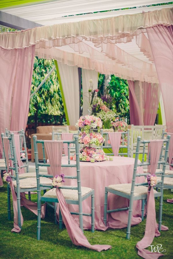 an outdoor wedding setup with pink and blue chairs