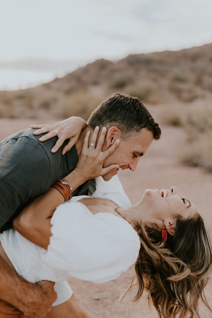 a man holding a woman in the desert