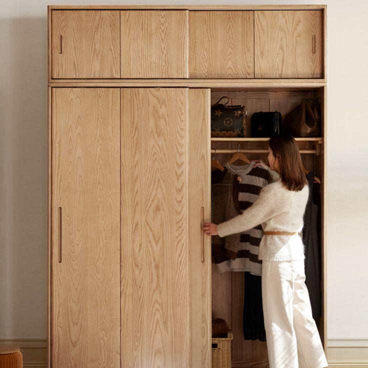 a woman standing in front of a wooden closet