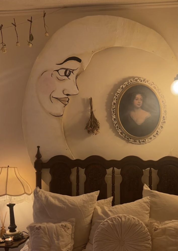 a bed with white sheets and pillows in front of a painting on the wall above it