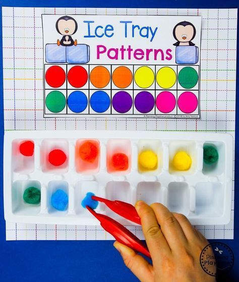 a hand holding a pair of scissors next to an ice tray pattern