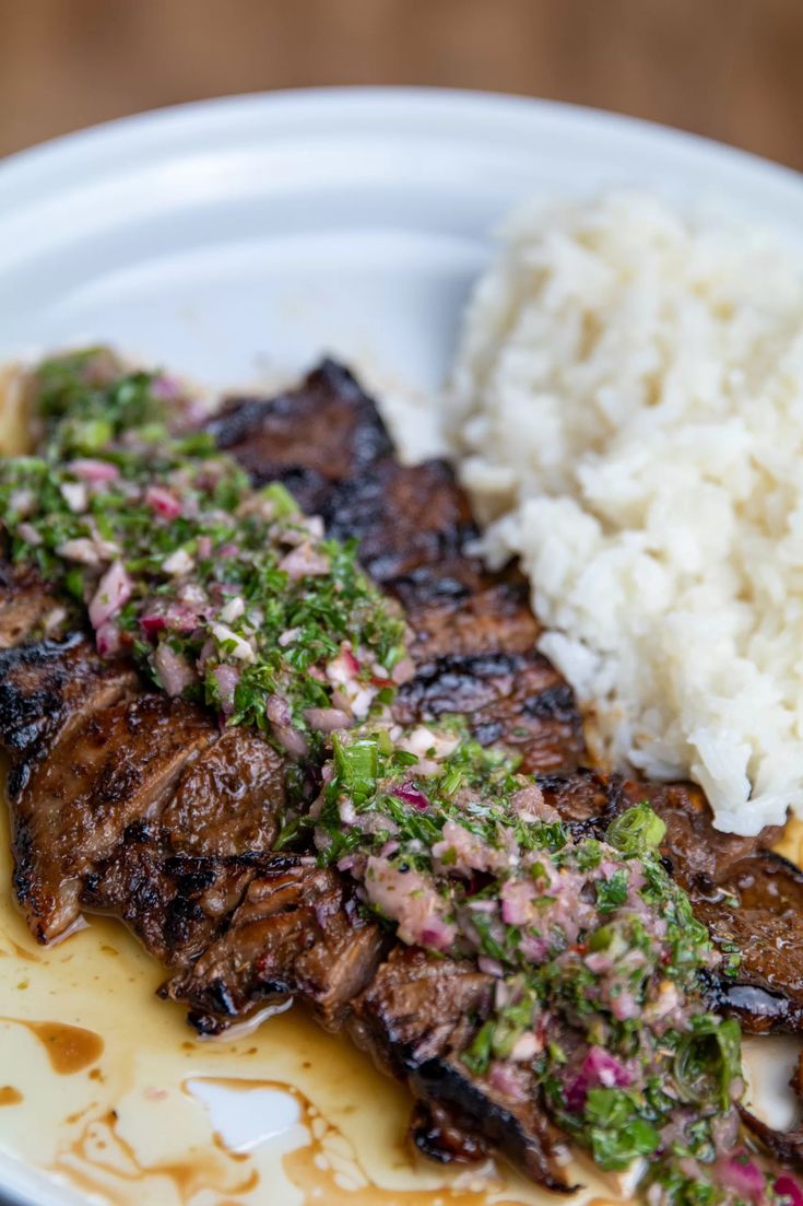 a white plate topped with meat and rice