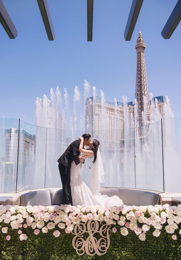 a bride and groom kissing in front of the eiffel tower at their wedding