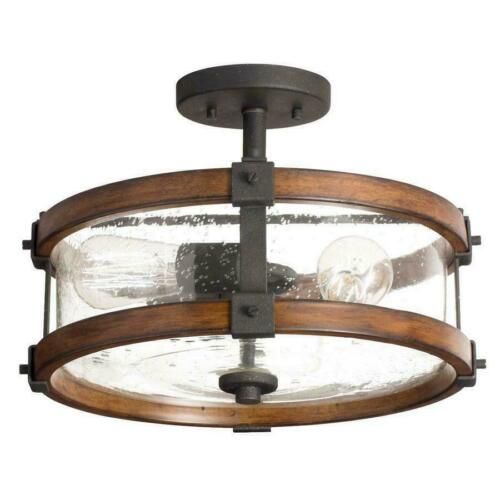 a semi flush ceiling light with clear glass and wood accents in an industrial style design