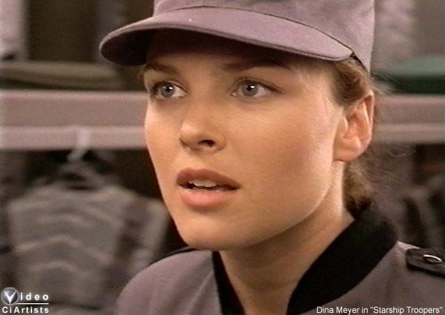 a woman wearing a baseball cap and looking off to the side with her eyes wide open