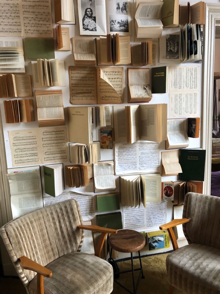 a room with many books on the wall and two chairs next to each other in front of them