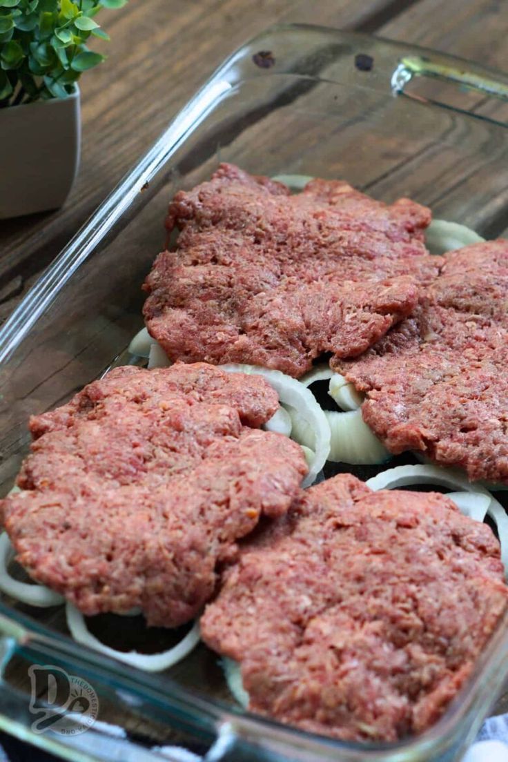 hamburger patties in a glass dish with onions