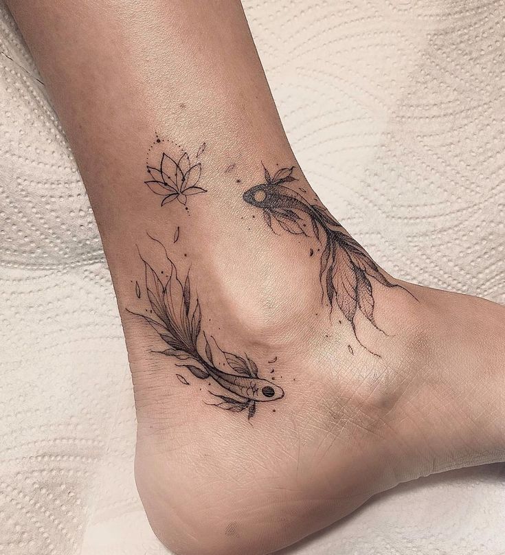 a woman's foot with a fish and leaves tattoo on the bottom of it