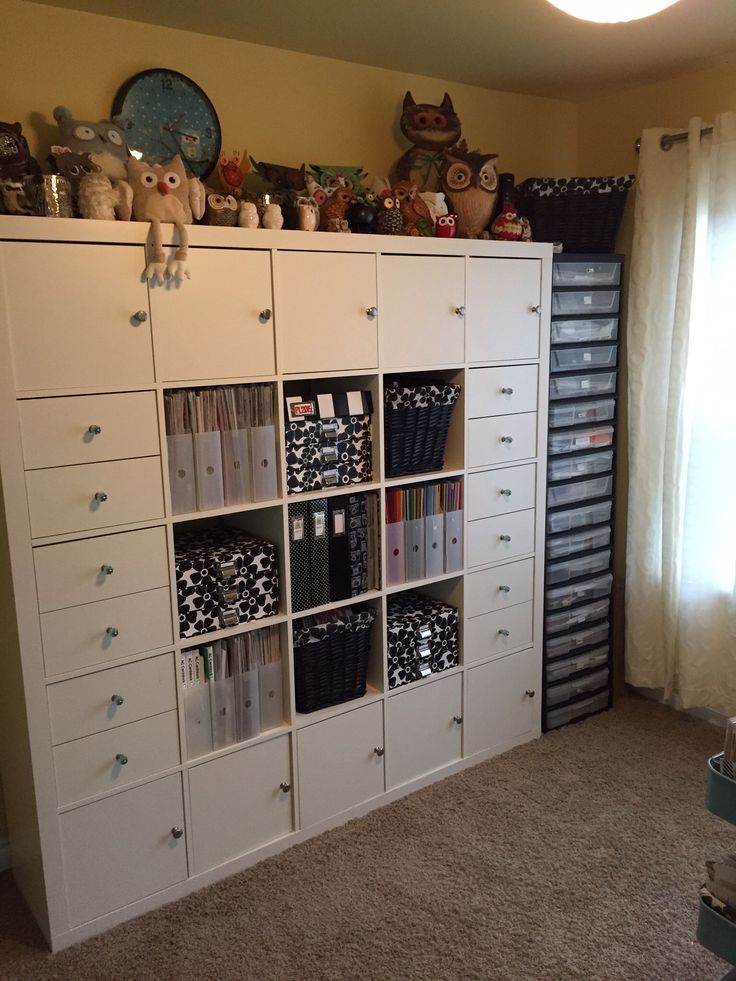 a white bookcase filled with lots of books on top of a carpeted floor