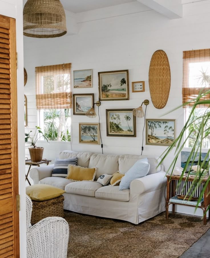 a living room filled with furniture and pictures on the wall