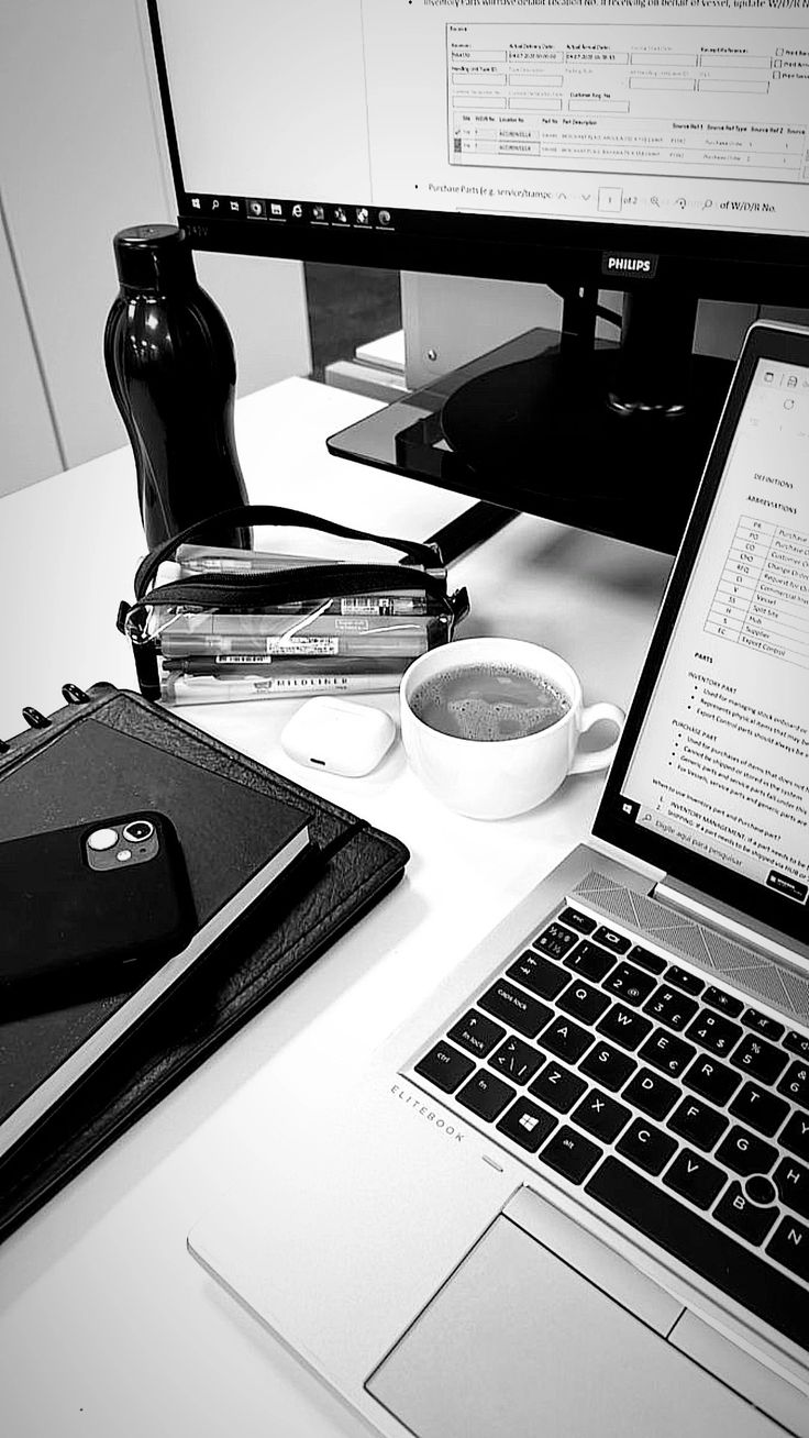 an open laptop computer sitting on top of a desk next to a cup of coffee