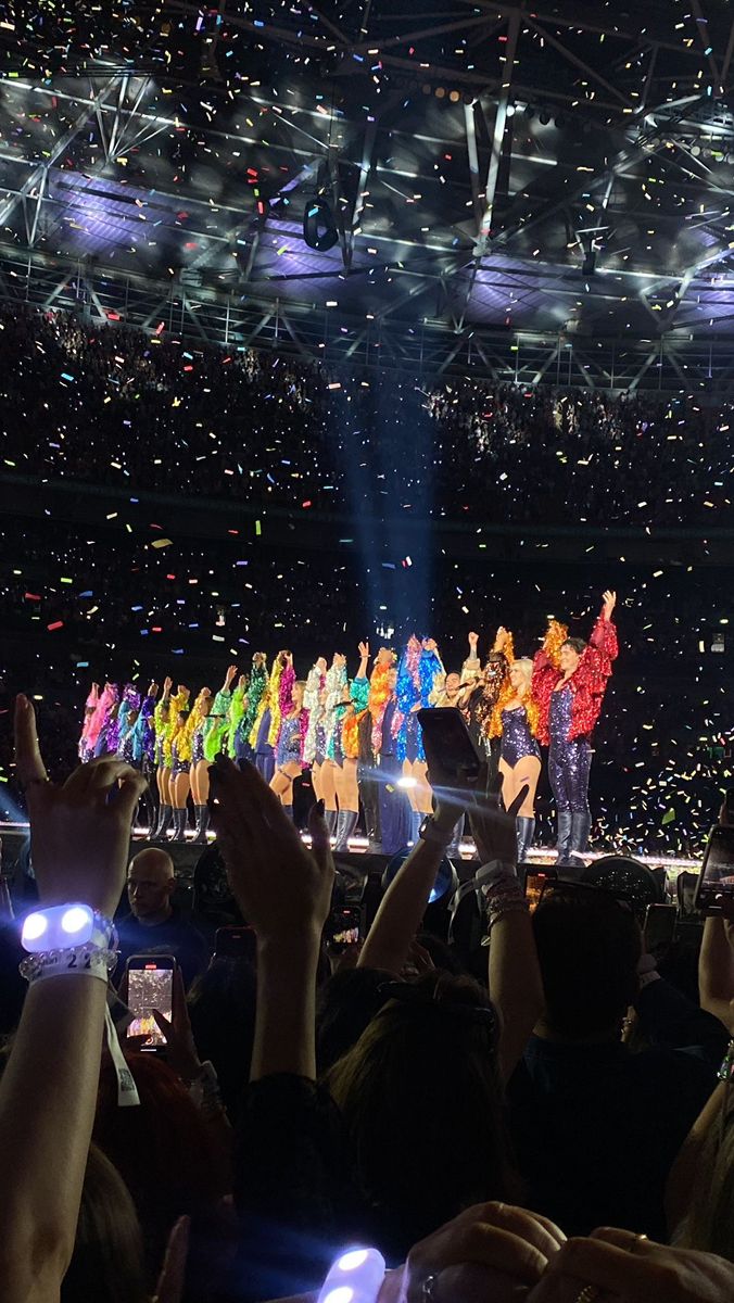 a group of people standing on top of a stage with confetti in the air