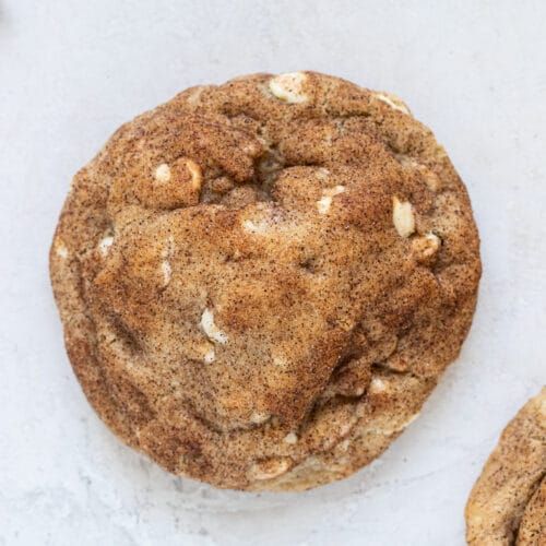 two chocolate chip cookies sitting on top of a white countertop next to each other