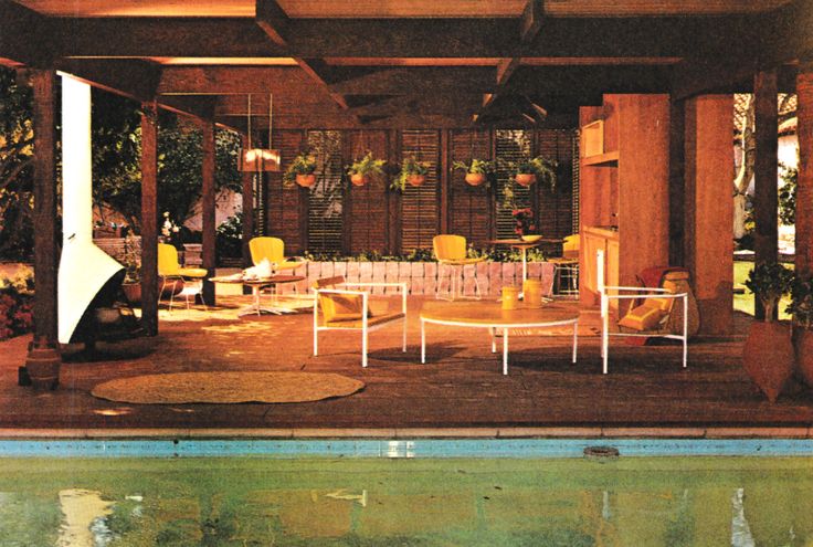 an indoor pool with chairs and tables next to the swimming pool in front of it