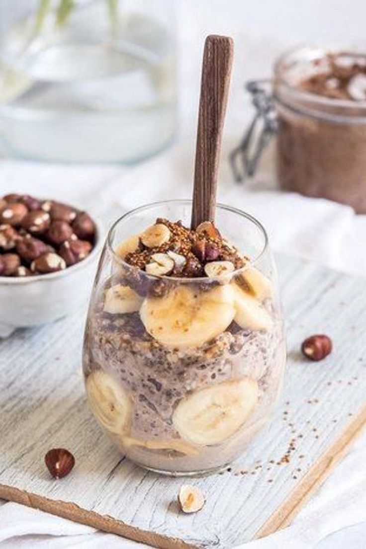 two bowls filled with different types of food on top of a wooden tray next to some nuts