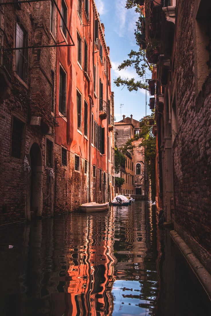 an alley way with buildings and water in the foreground