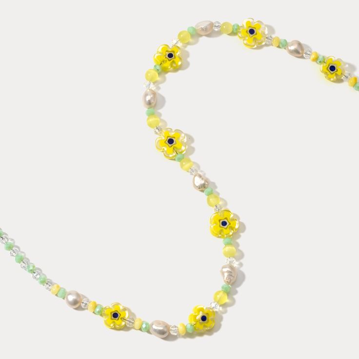 Sunshine around your neck! This delightful Pearl Yellow Flower Beaded Necklace features 18k gold-plated brass and blooms with sparkling crystals and soft yellow pearls. For the nature lover, this color stone necklace captures the beauty of a blooming garden in wearable form, serving as a constant reminder of the wonder and joy found in the natural world. The delicate pearls, sunny gemstones, and pops of vivid color stones come together to create a piece that is both visually stunning and deeply symbolic. DETAILS Plating: 18K Gold Materials: 18K Gold on Brass, Pearl, Natural Stone, Quartz, Crystal Measurements: Length: 16.14"(41cm) + Extender: 2.36"(6cm) Bead Size: 0.39"* 0.51 "(1.0cm*1.3cm) Weight: 19.1 g Yellow Pearl Beaded Necklaces As Gift, Yellow Flower Necklace For Summer, Summer Yellow Flower Necklaces, Summer Yellow Flower Necklace, Yellow Beaded Necklaces For Spring, Summer Gold Jewelry With Flower Decoration, Spring Adjustable Gold Flower Necklace, Spring Jewelry With Colorful Beads In Gold, Adjustable Gold Flower Necklace For Spring