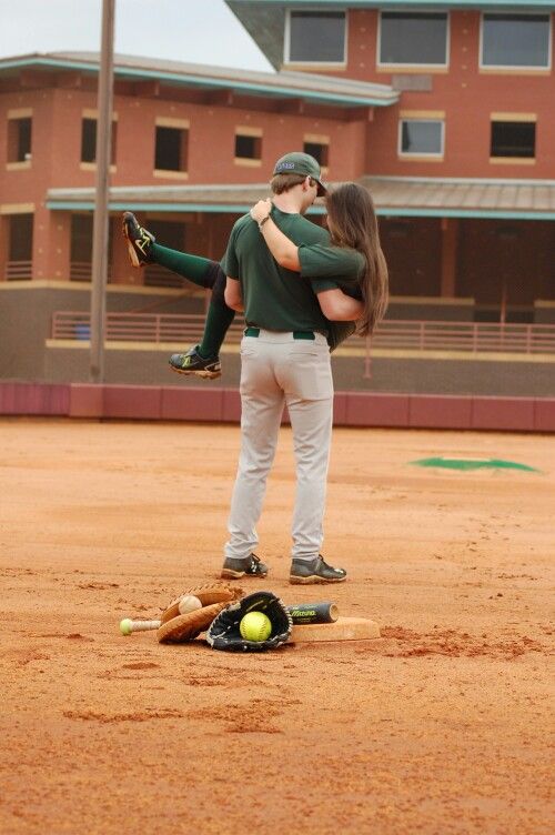 two baseball players embracing each other in the outfield with balls and bats on the ground