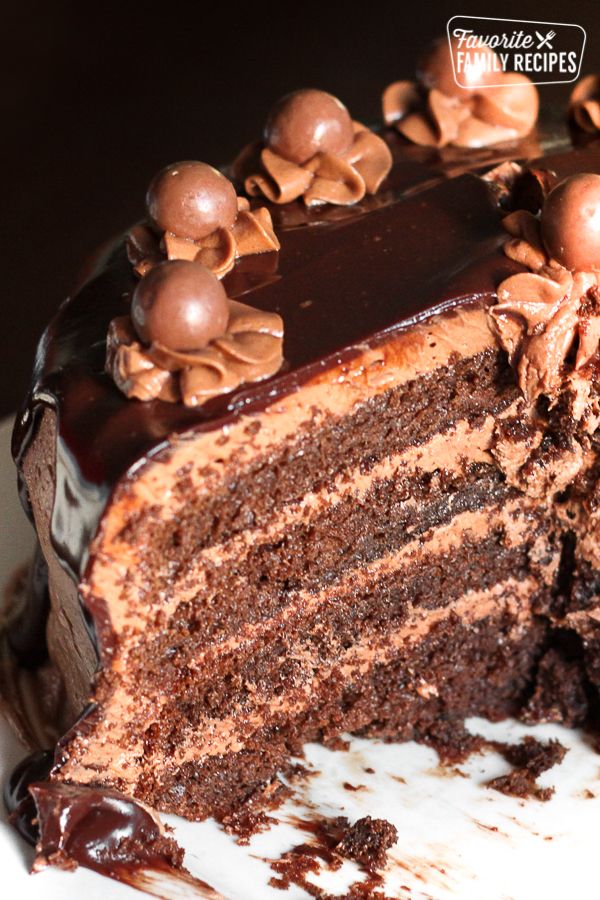 there is a chocolate cake with nuts on the top and one slice missing from it