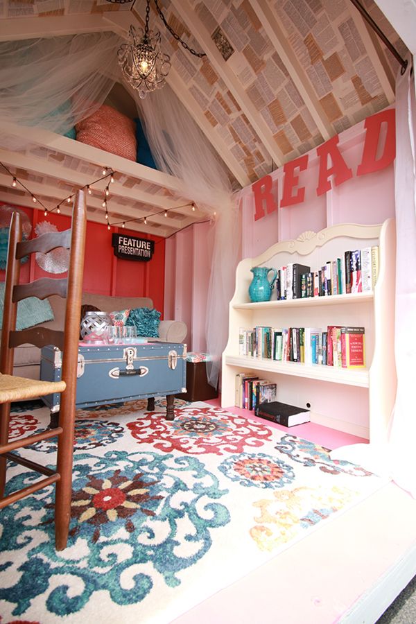 a room with a bed, bookshelf and rug on the floor